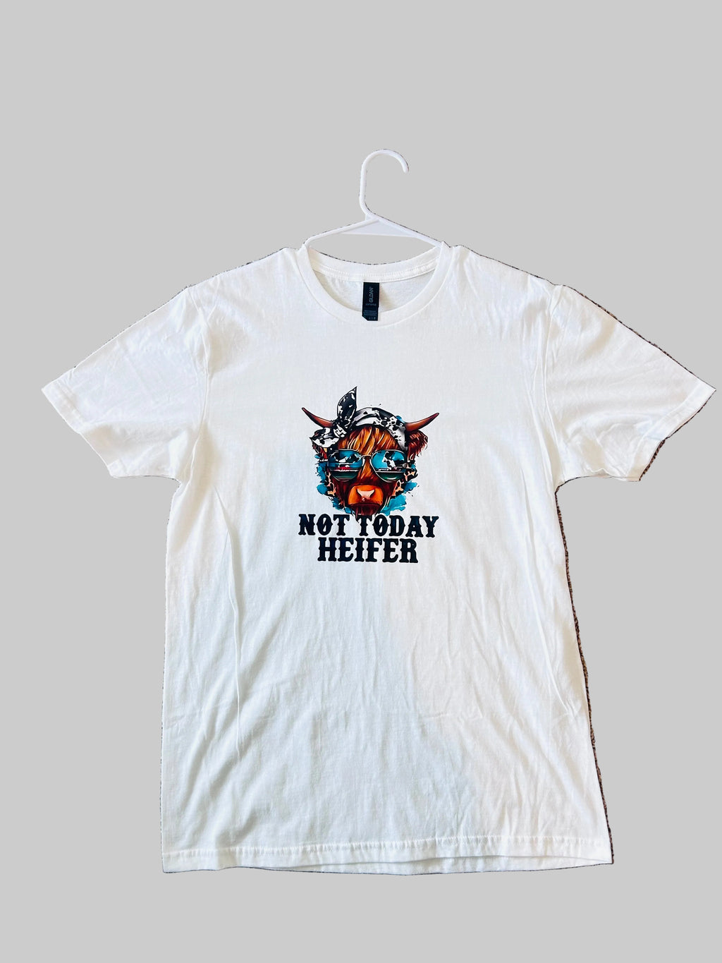 White t-shirt with 'Not Today Heifer' graphic on a beige carpet