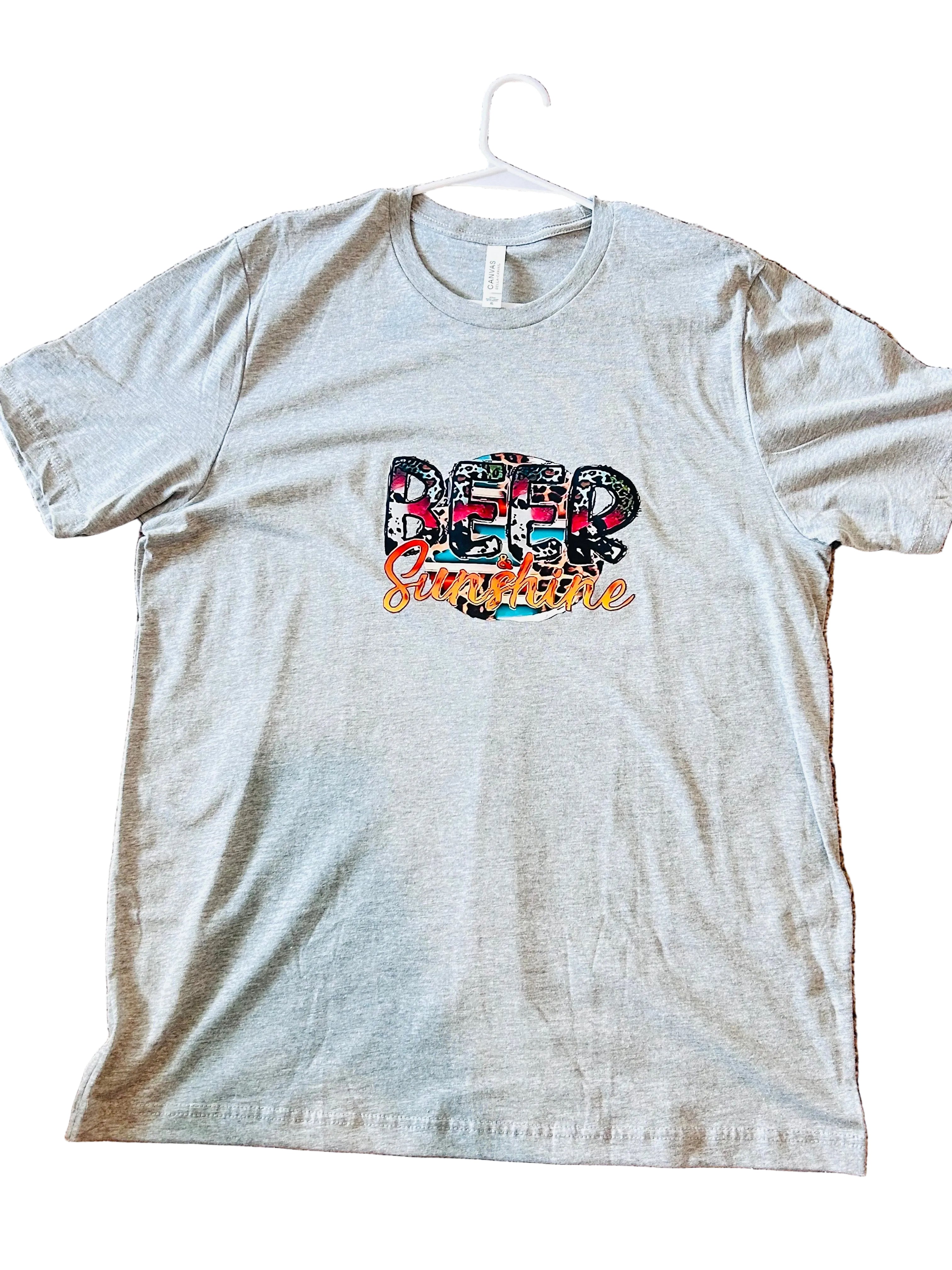 Gray t-shirt with colorful 'Beer Sunshine' text design on a beige carpet