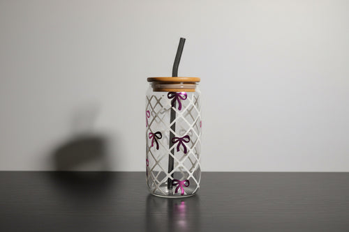 Clear glass tumbler with wooden lid on a dark surface